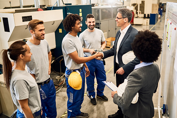 Happy company manager greeting with African American worker whil